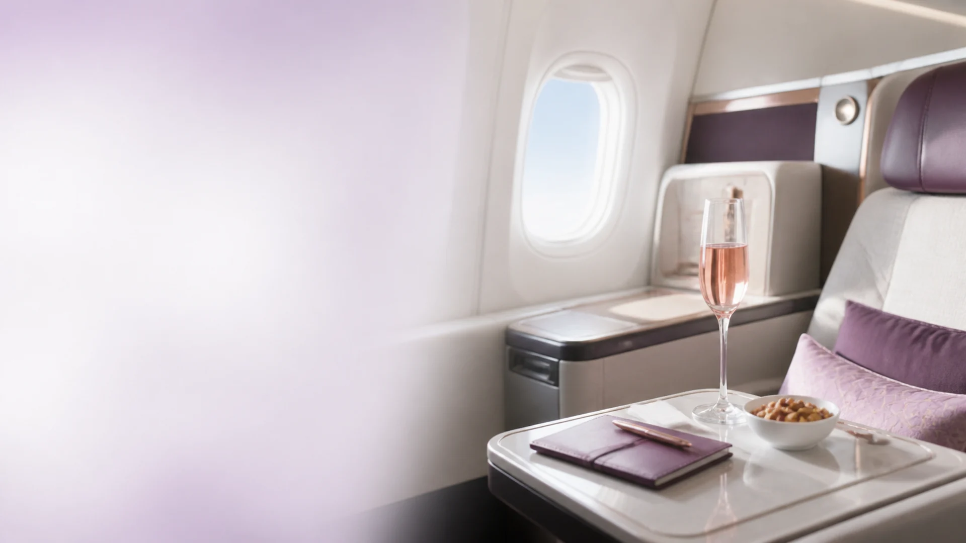 Business-class cabin and welcome drink representing NannyMoon referral rewards