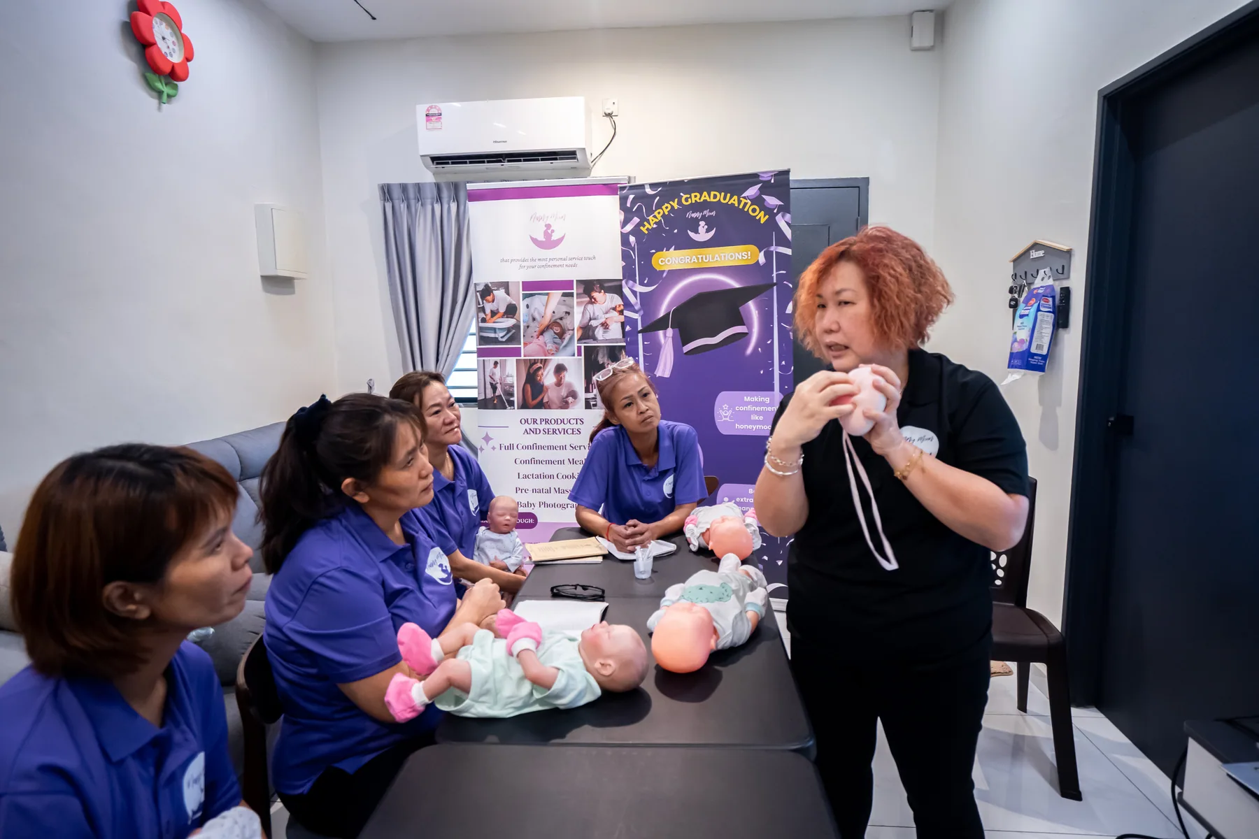 Trainer demonstrating mother and baby support techniques